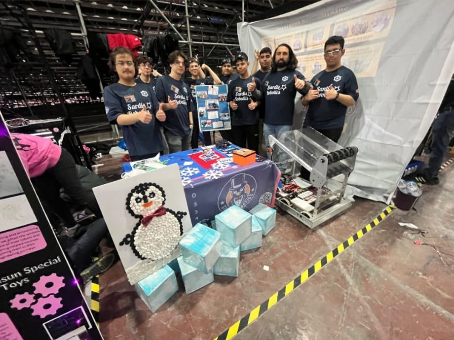 Etkinlik standında robotla birlikte duran Sardis Robotics takımı.